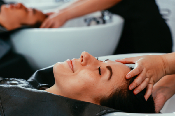 hairdresser washing woman's hair