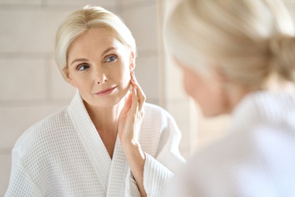 mature woman looking at mirror reflection