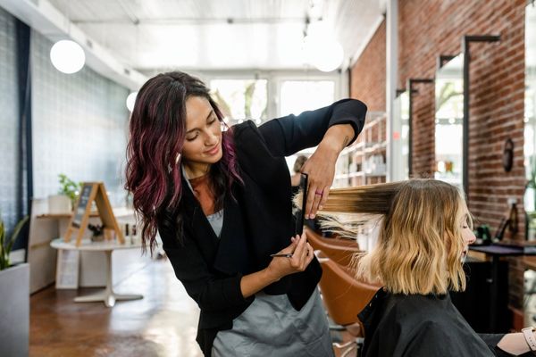 hairstylist trimming woman's hair